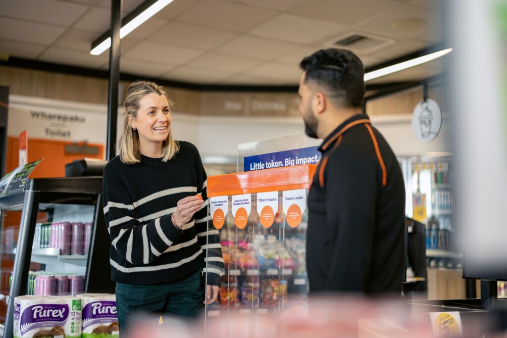 Women putting her orange token in the box in store at Z station